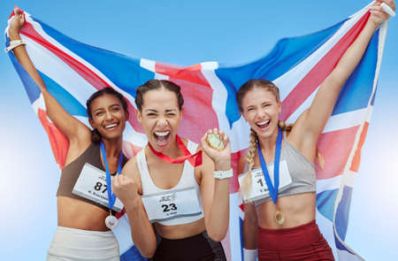 Diver British athletes celebrating their gold medal wins, waving a Union Jack flag. Happy and proud champions of United Kingdom. Winning a medal for your country is an amazing achievementの写真素材