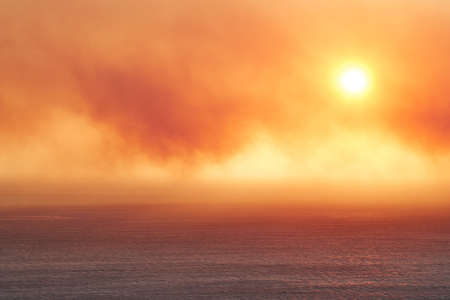 Seascape of a beautiful golden sunset with copy space. Sun setting on the horizon of a calm ocean at...