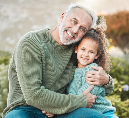Family is a divine connection by love. Shot of a grandfather and granddaughter spending time together outside.の写真素材