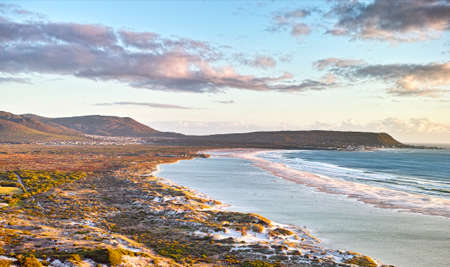 Seascape, lanscape, scenic view of Hout Bay in Cape Town, South Africa at sunrise. Blue ocean and sea with mountians in the morning. Beach travel destination or vacation location for a holidayの写真素材