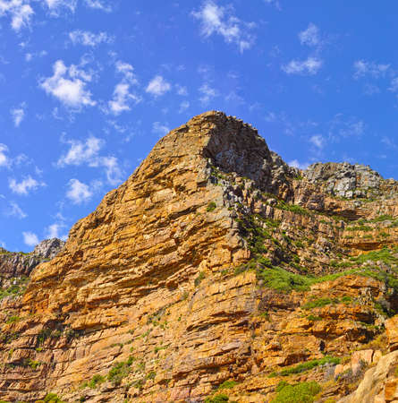 Low angle view of a mountain peak in South Africa. Scenic landscape of a remote hiking location on Lions Head in Cape Town during a sunny day. Travelling and exploring nature through adventureの写真素材
