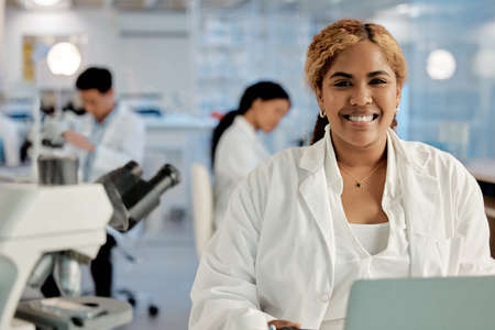 She never misses an opportunity. Shot of a young female lab technician in her office.の写真素材
