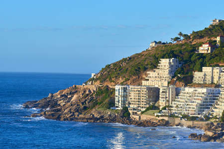 Clifton, Cape Town, South Africa panorama seascape with clear blue sky, hotels, and apartment buildings in the background. Housing development overlooking the beautiful blue ocean peninsulaの写真素材