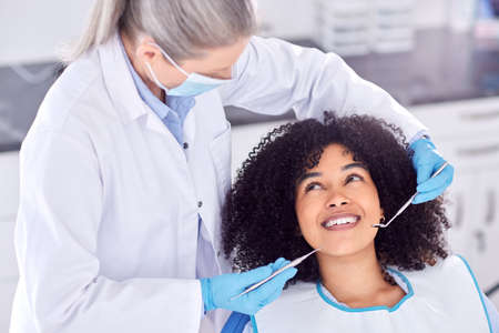 .. Shot of a young female patient having her teeth examined at the dentist.の写真素材