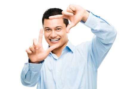 The perfect shot. Shot of an asian businessman framing his face using his fingers against a studio...