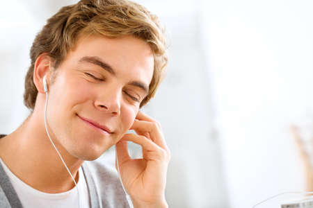 Music is the balm to my soul. Shot of a young man listening to music at home.の写真素材