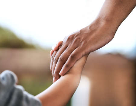 Hold my hand tightly. Shot of an unrecognizable parent and child holding hands at home.の写真素材