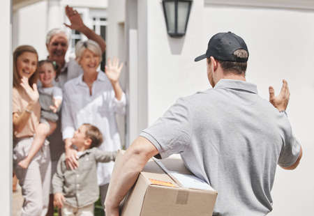 Eagerly awaiting his arrival. Cropped shot of a family waving at a male courier who is out making deliveries.の写真素材