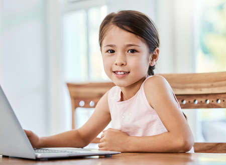 Live your life with love as your guiding principle. Shot of a little girl using a laptop at home.