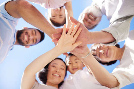 Weve got the family spirit. Shot of a family stacking their hands outside.