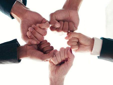 Together we can do so much more. Low angle shot of a group of unrecognizable businesspeople joining their hands together in a unity.の写真素材