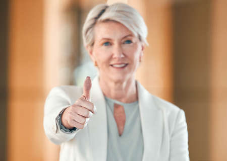Youve got my support. Shot of a mature businesswoman showing a thumbs up at work.の写真素材