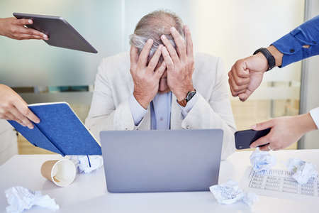 When theres too much going on. Shot of a mature businessman looking overwhelmed in a demanding work environment.の写真素材