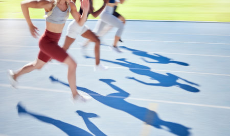 Shadow of athletes running and racing together on a sports track. Closeup of active and fit runners...