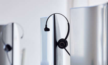 We are unavailable right now, be try again later. Closeup shot of a headset resting on a computer...