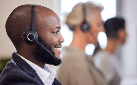 Lets smash this sales game. Shot of a young call centre agent working in an office with his...