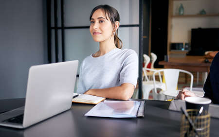 Ideas loading.... Shot of a young businesswoman sitting in on a meeting in an office.の写真素材