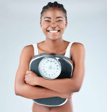 Practise self-love and youll always be happy with the number on the scale. Closeup shot of a fit young woman posing with a weight scale.の写真素材
