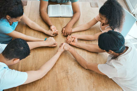 Stay covered in a world thats lost its purpose. Shot of a family praying together at home.の素材 [FY310188577743]