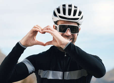 In love with cycling. Cropped shot of a handsome mature man making a heart shape with his hands...