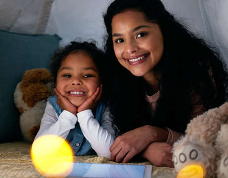 I love those most whom I loved first. Shot of a little girl and her mother watching something on a...