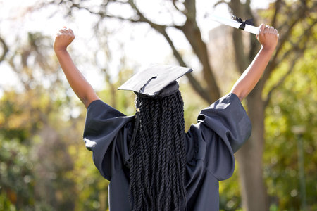 Look forward to what tomorrow brings. Rearview shot of a young woman cheering on graduation day.の写真素材