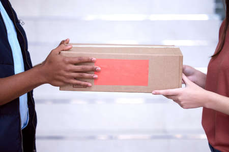 Your delivery has arrived. Shot of a woman accepting her delivery from the delivery man.