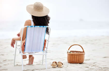 Its a perfect beach day. Shot of a young woman enjoying a day at the beach.の写真素材