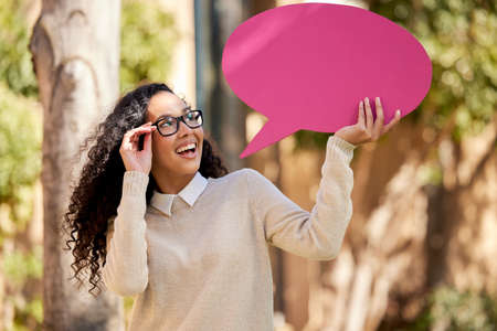 Thinking myself into a brighter future. Shot of a beautiful young student holding a speech bubble...