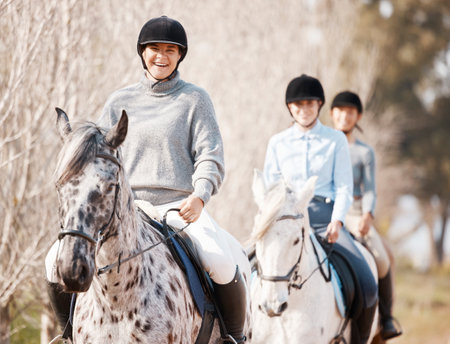 A good horse is hard to replace. Shot of three attractive young women horse riding on a farm.