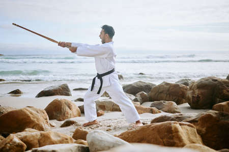 Your spirit is the true shield. Shot of a young martial artist practising karate with a wooden...