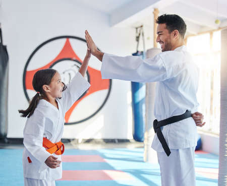 Courage conquers all. Shot of a young man and cute little girl practicing karate in a studio.の写真素材