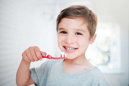 I love the minty taste. Shot of a little boy brushing his teeth in a bathroom at home.