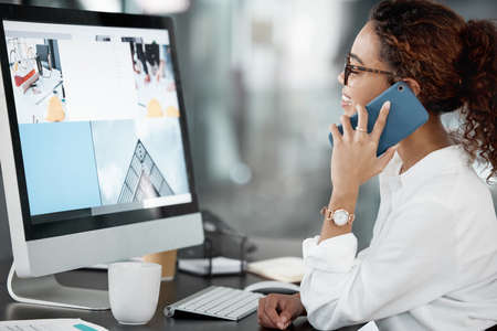 Im looking at the designs now. Cropped shot of an attractive young businesswoman making a phonecall...