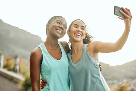 Building our dream bodies together. Shot of two friends taking selfies during a workout.