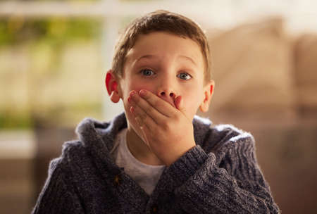 Dad said not to spill. Portrait of a cute little boy reacting to something surprising while sitting...