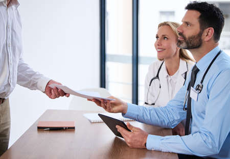The paperwork you needed. Shot of a group of doctors in a meeting at a hospital.の写真素材