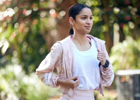 Moving at a relaxed pace. a sporty young woman running outdoors.