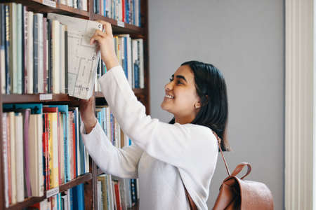 I think Ive found the one. a young woman reading a book in her school library.