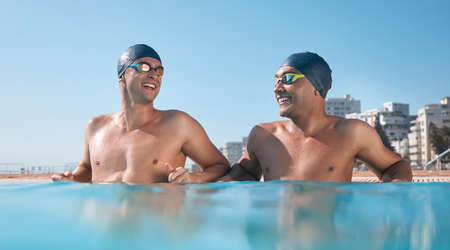 two young men going for a swim in pool.