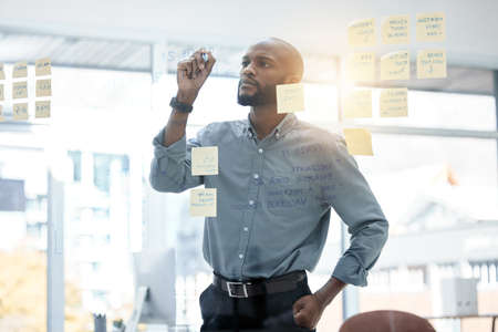 The futures looking really bright. a young businessman brainstorming in an office at work.の写真素材