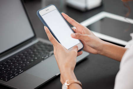 Stay on top of it by staying on tap. an unrecognizable businesswoman using her cellphone while sitting at her desk.の写真素材