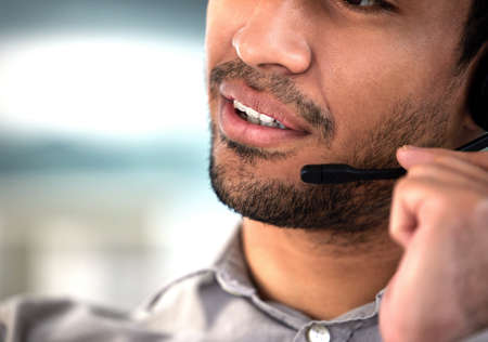 Next caller please. an unrecognisable customer service agent talking into his headset in the office.