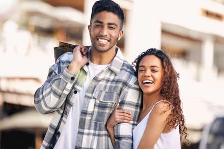 Ill always hold you close. a young couple spending the day shopping together.の写真素材