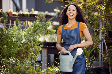 Im ready to water these plants. a young female florist watering plants at work.の写真素材