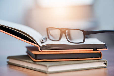 What plans have you made towards your goals. Closeup shot of a pair of spectacles on a pile of...
