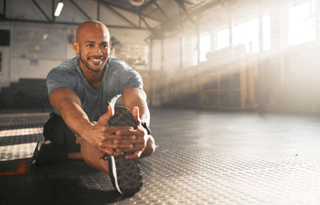 Never skip this step. a young man stretching his legs before a workout.