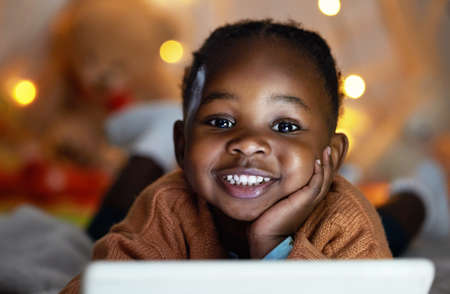 Whats your favourite bedtime story. an adorable little girl using a digital tablet during bedtime at...
