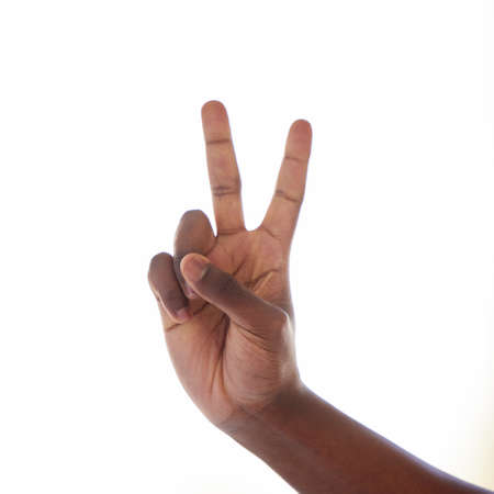 Two minutes please.... Studio shot of an unrecognisable man making a peace sign against a white background.の写真素材