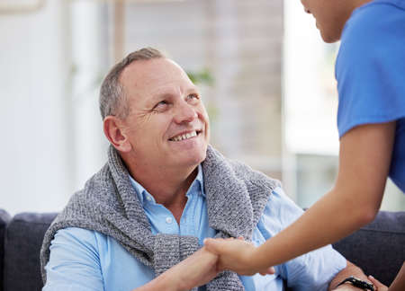 Lets get you on your feet. a senior man sitting in the clinic while his nurse helps him.